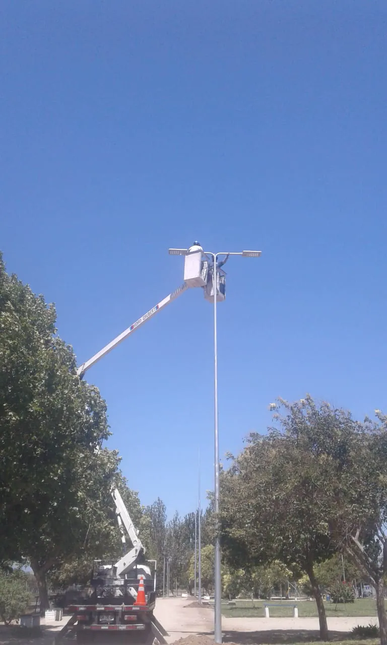 Camión con brazo elevador en mantención de luminaria LED en poste de alumbrado público