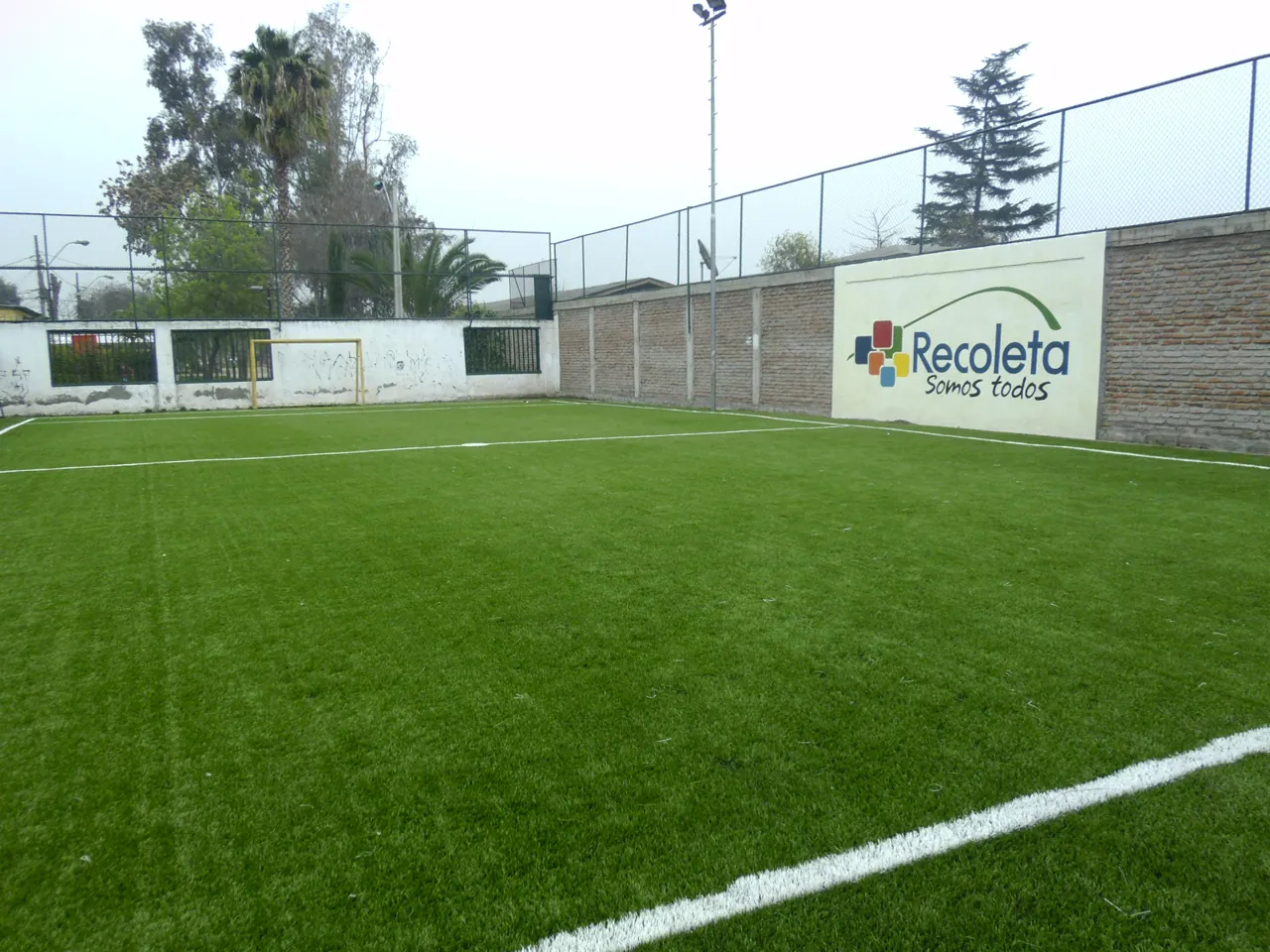Cancha de pasto sintético construida por EDT con el logo municipal de Recoleta