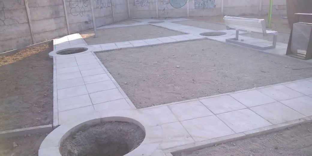 Construcción de plaza con pavimentos de hormigón y maceteros circulares